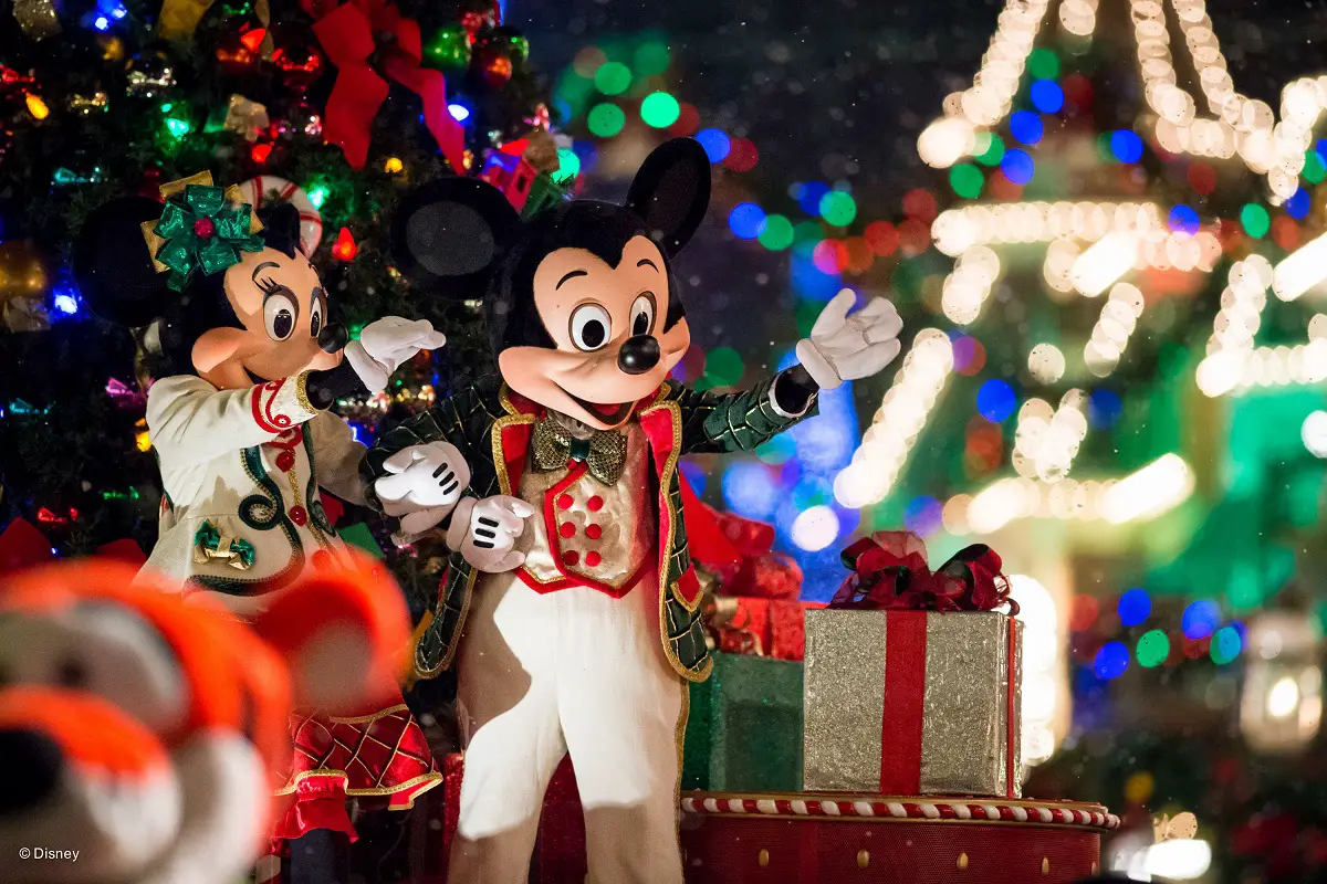 mickey y minnie vestidos con ropa navideña, cerca de un árbol con varios regalos