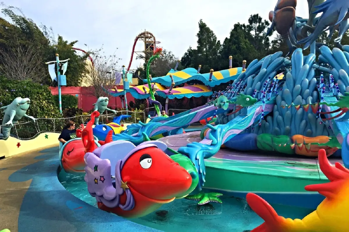 Carrousel avec bancs en forme de poisson à One Fish, Two Fish, Red Fish, Blue Fish avec des enfants à l'intérieur des bancs