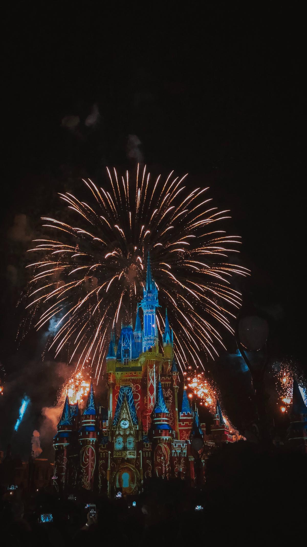 Imagen de espectáculos nocturnos de Disney con coloridos fuegos artificiales y castillo iluminado