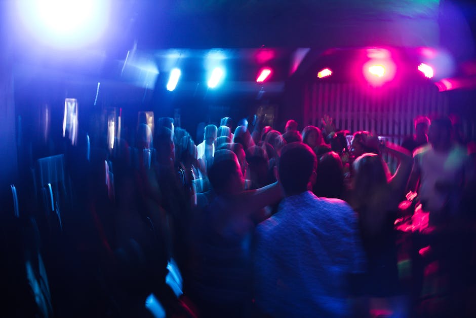 Imagem de vida noturna na Flórida, mostrando pessoas se divertindo em um clube com luzes coloridas e música animada.